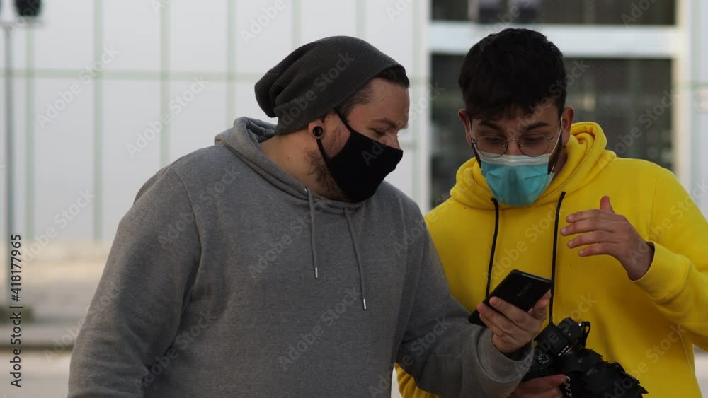 Amigos hablando en un banco durante la pandemia del coronavirus respetando las medidas de seguridad y distanciamiento social del covid-19