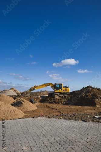 new development area, power shovel,digger, construction vehicle, in Ascheberg, Germany under blue sky, copy space, vertical shot