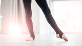 Beautiful ballerina legs during dance class exercices in sunny studio