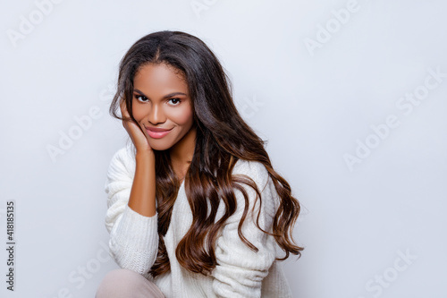 Happy Black Girl Smile in White Sweater with long curly hair. Relaxed and Carefree. Portrait of beautiful black woman in white sweater with long curly hair. 