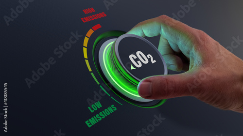 Lower CO2 emissions to limit global warming and climate change. Concept with manager hand turning knob to reduce levels of CO2. New technology to decarbonize industry, energy and transport photo