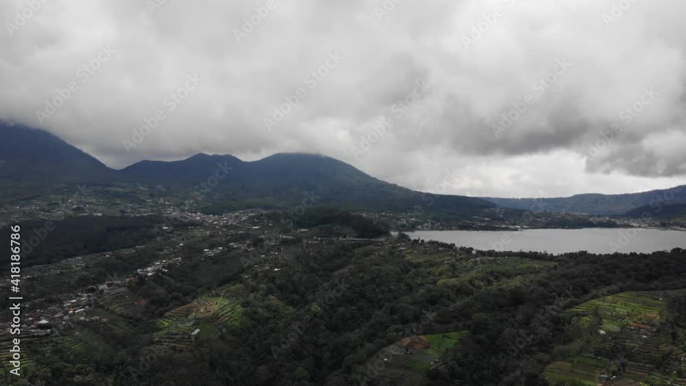 A slow pan overlooking a stunning tropical city residing on the side of a lake. Aerial video.