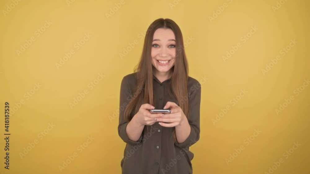 Young long-haired woman picks up a message on the phone and laughs, 4K