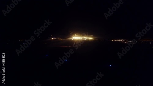 Airplane window passenger pov  of plane landing on illuminated airport at night photo