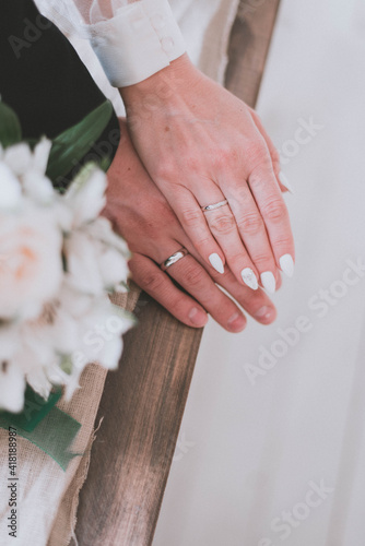 Wedding rings close-up. The wife put her hand on her husband's hand