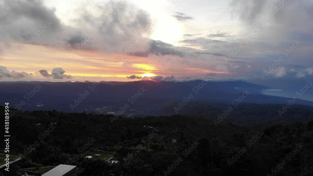 Aerial view of forest, mountains with fog, clouds at sunset on Indonesia. Tropical rainforest, trees, jungle in mountains. Aerial view of forest, mountains with fog, clouds at sunset on Indonesia. Tropical rainforest, trees, jungle in mountains.