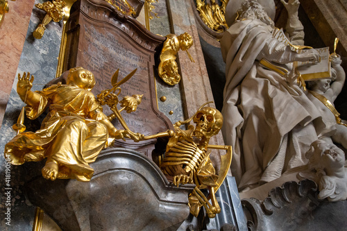 a carving showing a golden skeleton snipping the thread of life