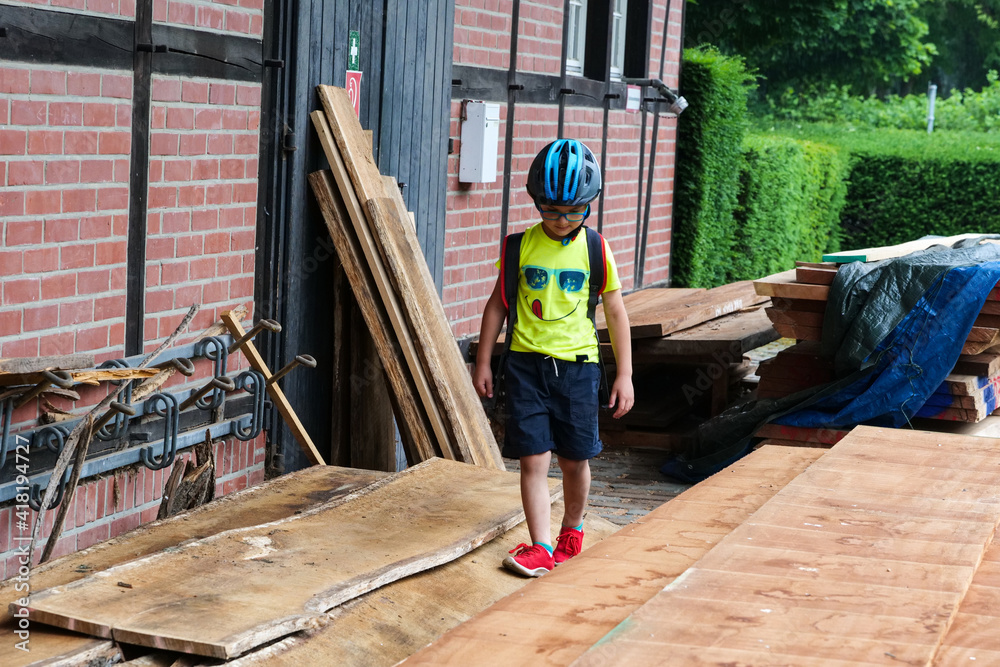 Ein Junge mit Helm 6 Jahre alt läuft auf Holzbrettern. 