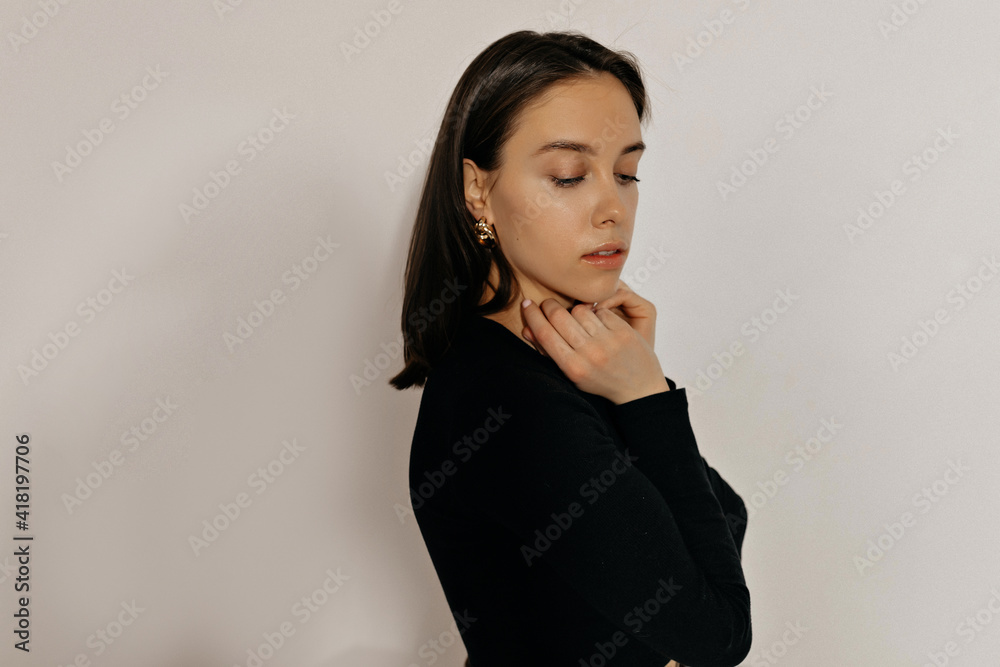 Charming attractive lady with short dark hair wearing black closed posing with closed eyes over isolated background Charming attractive lady with short dark hair wearing black closed posing with closed eyes over isolated background