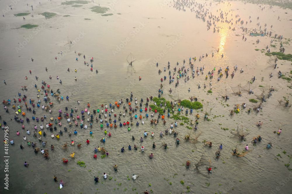 Aerial view of people fishing in group in a traditional fishing culture along the swamp, Chatmohar, Rajshahi province, Bangladesh. Aerial view of people fishing in group in a traditional fishing culture along the swamp, Chatmohar, Rajshahi province, Bangladesh.