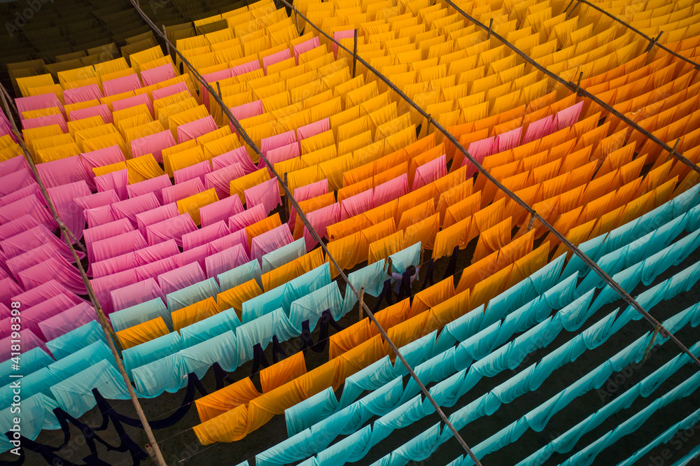 Aerial view of a person working in a public laundry hanging for drying colourful cloth in Narayanganj, Dhaka, Bangladesh. Aerial view of a person working in a public laundry hanging for drying colourful cloth in Narayanganj, Dhaka, Bangladesh.