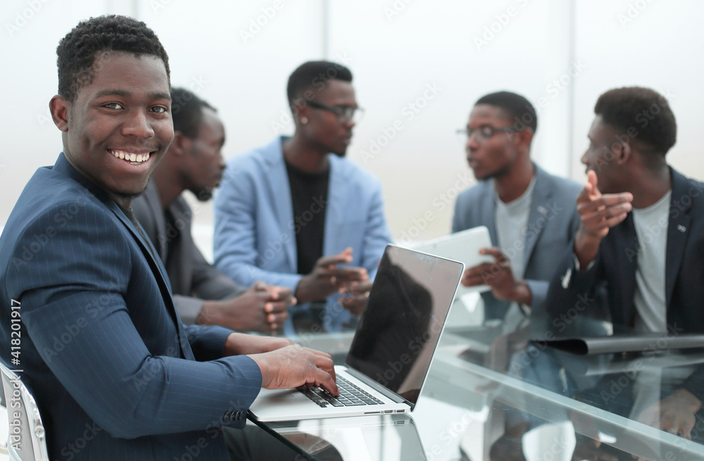 young businessman uses laptop sitting at office Desk. young businessman uses laptop sitting at office Desk.