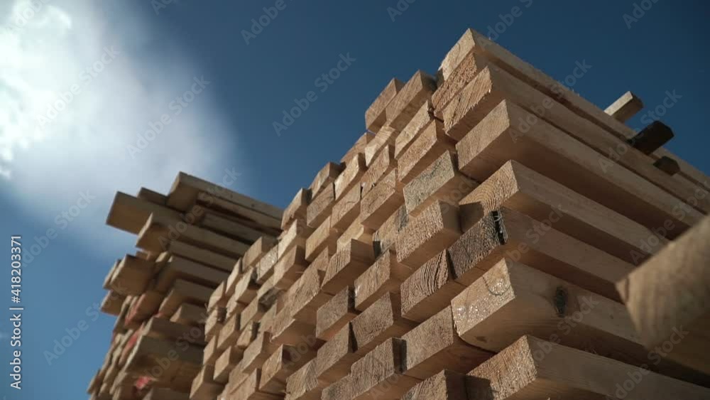 Wooden bars. Rafters for building a house. Packs of lumber at the Sawmill. Big framework. Natural materials from wood. Time lapse. Pine Boards in large packages. Manufacture of wooden products Wooden bars. Rafters for building a house. Packs of lumber at the Sawmill. Big framework. Natural materials from wood. Time lapse. Pine Boards in large packages. Manufacture of wooden products