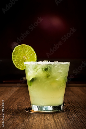 Fresh cocktail on a wooden table. Alcoholic lemon cocktail - Caipirinha