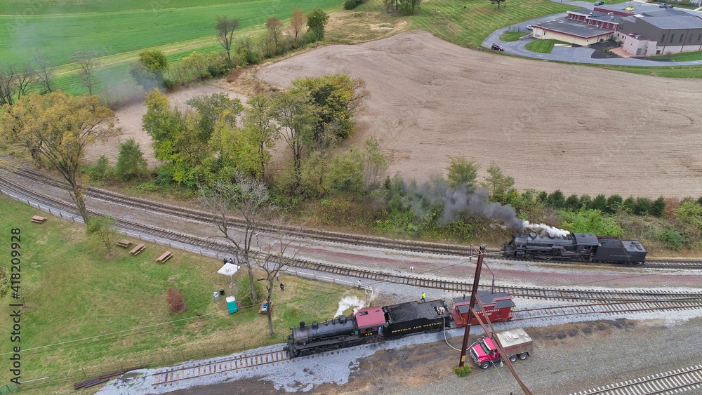 Aerial View of An Antique Restored Steam Locomotive Blowing Smoke and Steam Traveling Thru Farmlands and Countryside on a Sunny Summer Day Aerial View of An Antique Restored Steam Locomotive Blowing Smoke and Steam Traveling Thru Farmlands and Countryside on a Sunny Summer Day