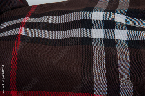 top view flat lay closeup on brown checked scarf with different strips