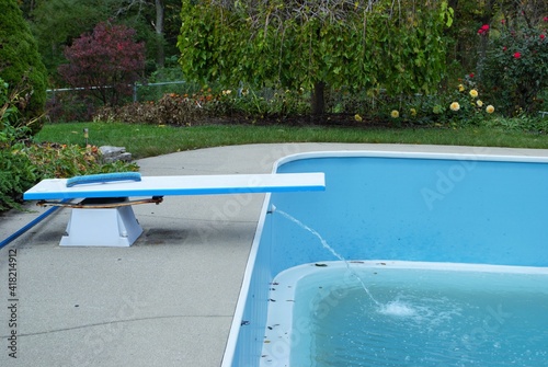 backyard swimming pool with diving board emptied out shutting down for winter