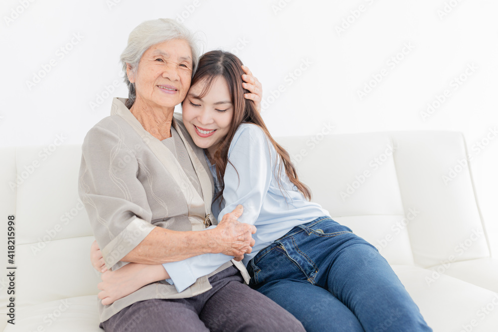 close up old woman, young Asian female hug old female in home, they feeling happy and smile, they sitting on sofa, mother's day, happiness elderly in family time close up old woman, young Asian female hug old female in home, they feeling happy and smile, they sitting on sofa, mother's day, happiness elderly in family time