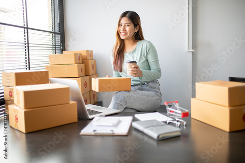Young asian woman is entrepreneur work from home with online on notebook, online shopping, logistic and delivery, female is seller working on sofa, business SME © David