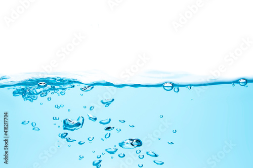 Water waves make bubbles and splashes in the clear blue water. Bubbles in blue liquid