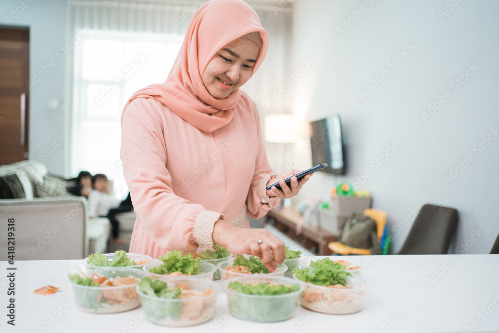muslim asian woman home catering service preparing lunch box for takeaway food online order muslim asian woman home catering service preparing lunch box for takeaway food online order