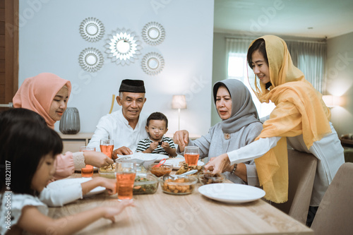 muslim asian family and grandparents having break fasting on ramadan. iftar dinner break