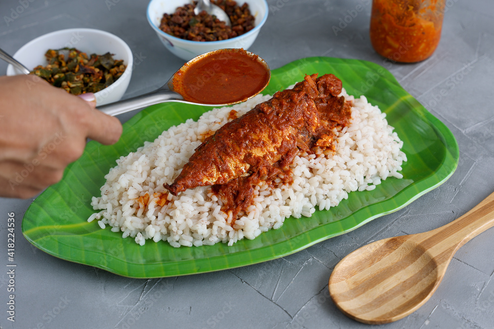 Spicy Mackerel fish curry and rice Hand serving Kerala fish curry