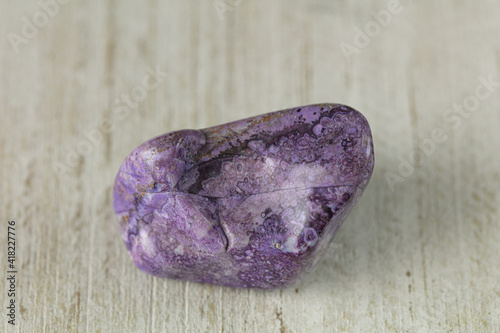 lepidolite  nature textured purple stone on wood white surface