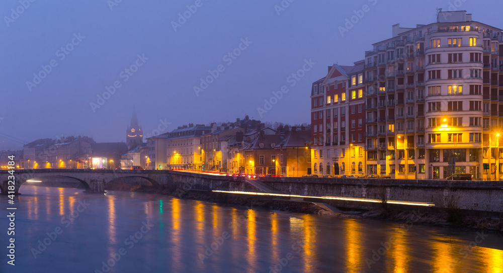 Cityscape of Grenoble with Isere river at winter twilight