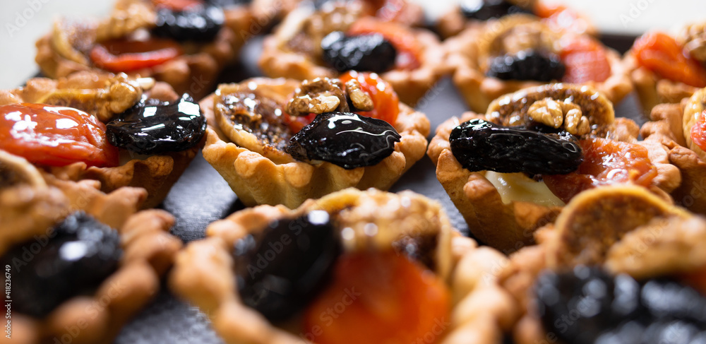 Shortcrust tartlets with fruit and walnuts. Fruit baskets with nuts. Small pies. Shortcrust tartlets with fruit and walnuts. Fruit baskets with nuts. Small pies.