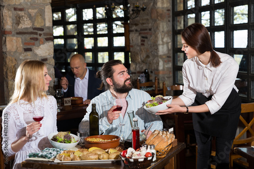 Happy people having dinner at rural restaurant and drinking wine. High quality photo