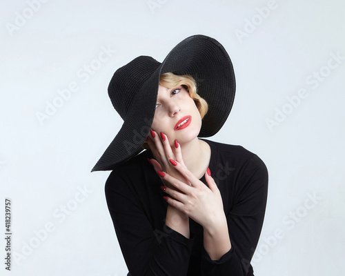 portrait of an attractive blonde with a retro hairstyle in a black hat with a wide brim