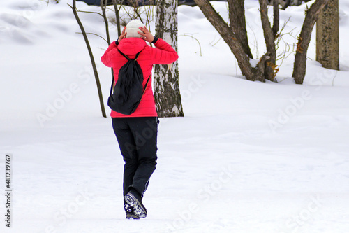 Fototapeta Naklejka Na Ścianę i Meble -  A woman takes a walk in a winter city park