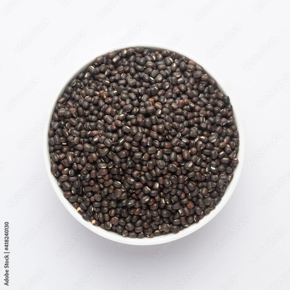 Close up of Organic Black Gram (Vigna mungo) or whole black urad on a ceramic white bowl. Top view Close up of Organic Black Gram (Vigna mungo) or whole black urad on a ceramic white bowl. Top view