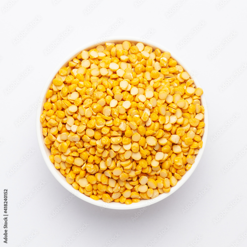 Close up of Organic Bengal Gram (Cicer arietinum) or split yellow chana dal on a ceramic white bowl. Top view 
