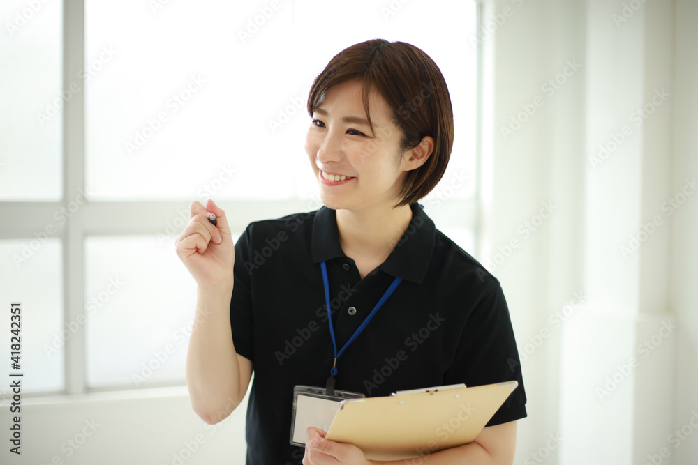 バインダーを持つスポーツジムインストラクター　イメージ