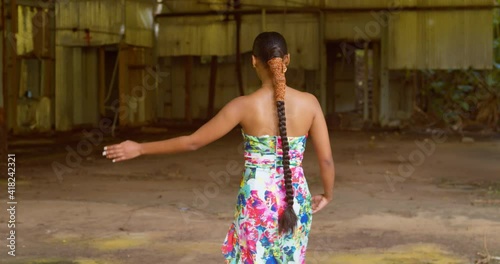 A young African Queen walks and enjoys herself before spinning in a 360 motion at an abandoned warehouse photo