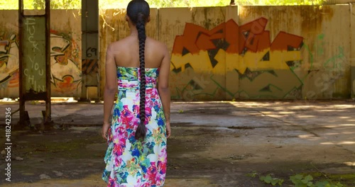 A model walks toward grafitti art on the wall at an abandoned warehouse photo