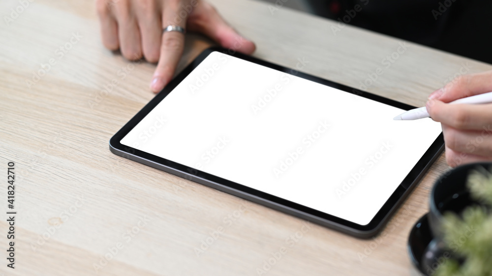 Close up view of man holding stylus pen pointing on empty screen of digital tablet. Close up view of man holding stylus pen pointing on empty screen of digital tablet.