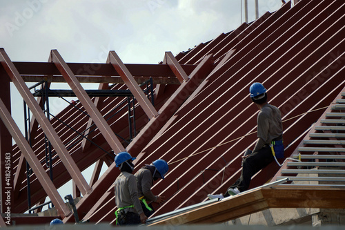 People are building the roof in a hurry