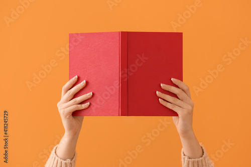 Woman with blank book on color background
