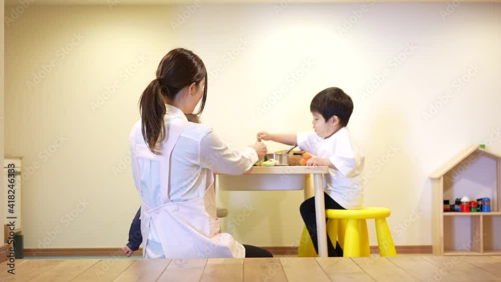 子供達と遊ぶ保育士の女性 子供達と遊ぶ保育士の女性