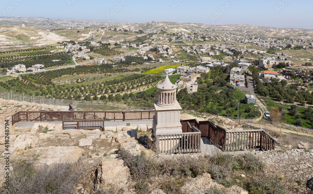 View  from walls of palace ruins of King Herod - Herodion of the restored model of the mausoleum, in which King Herod was buried, and nearby Jewish and Arab settlements in the Judean Desert, in Israel