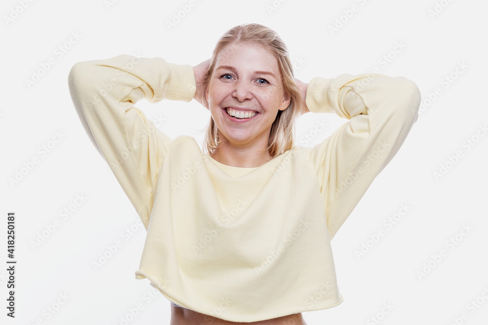 Laughing young woman. Freckled blonde in a yellow sweater. Optimism and positivity. White background. Laughing young woman. Freckled blonde in a yellow sweater. Optimism and positivity. White background.