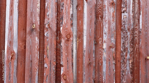 wooden background of textured planks with peeling paint of a red-brown hue  a fragment of a rustic old fence with a relief surface of boards layered on top of each other