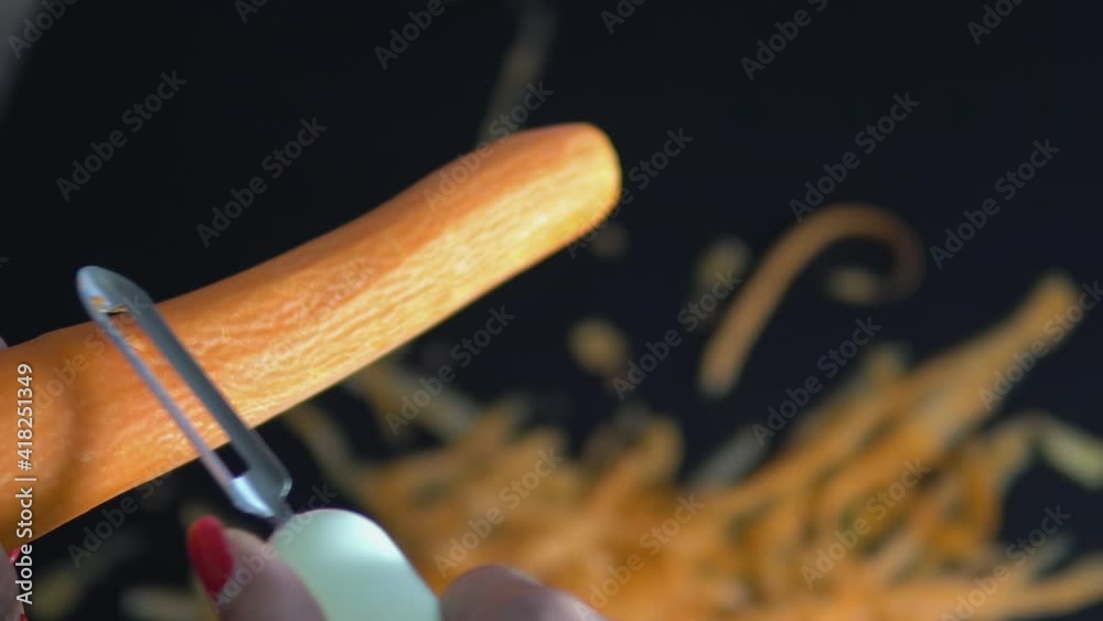 Hand slicing peeled carrot for cooking Hand slicing peeled carrot for cooking