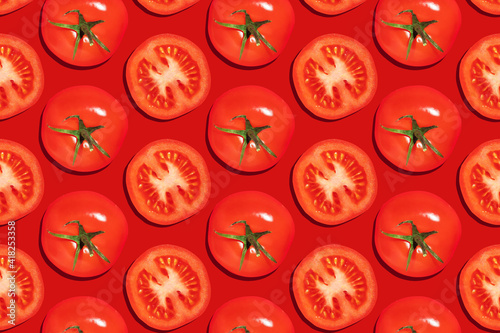 Seamless pattern of whole with green leaves and cut tomatoes on a red background © Hanna Haradzetska