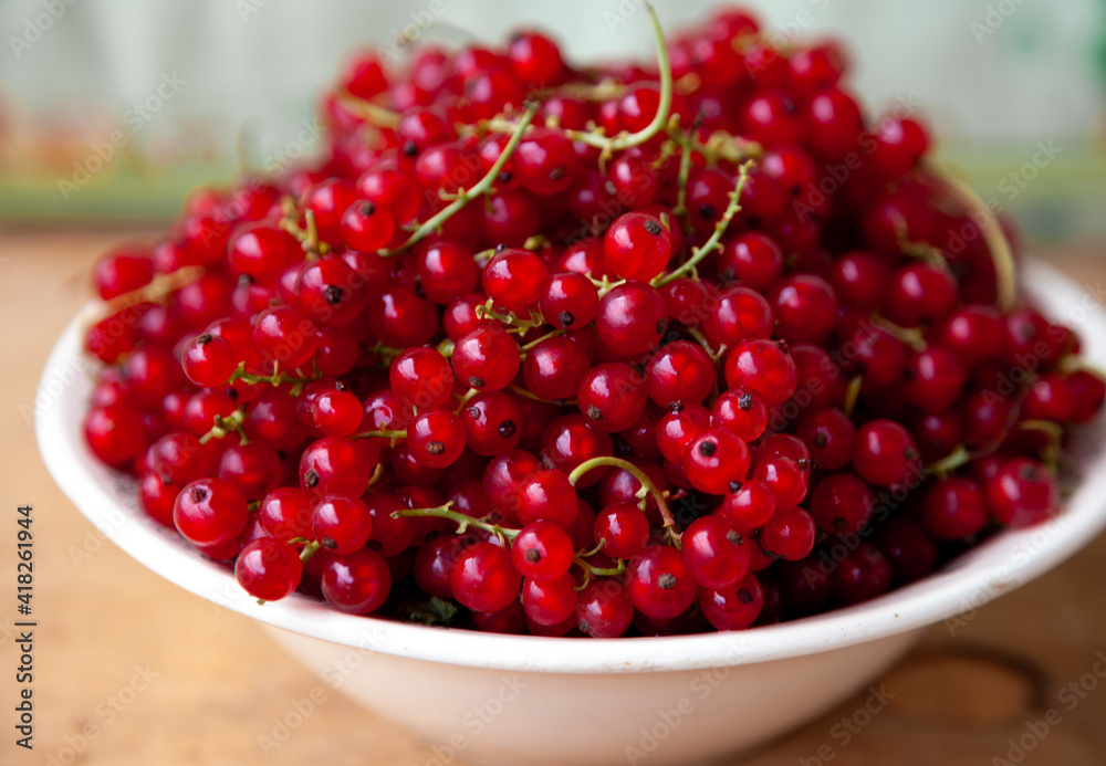 Currants in a bowl on a weeden background. Red berry. Vitamin berries. Copy space Currants in a bowl on a weeden background. Red berry. Vitamin berries. Copy space