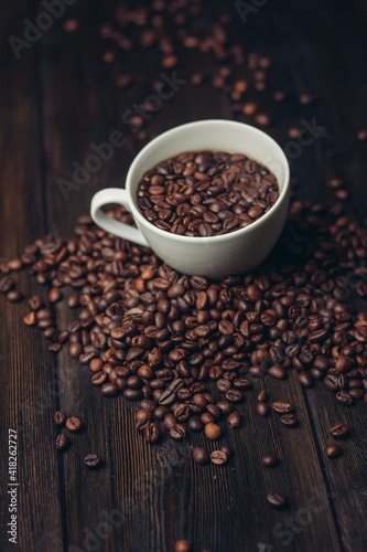 cup with coffee grains on a wooden table aromatic drink Arabica product