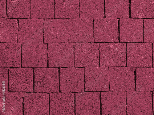 Brickwork of big bright textured crimson pink bricks, geometric square stones. Floor in a street, tiles underfoot. Backdrop